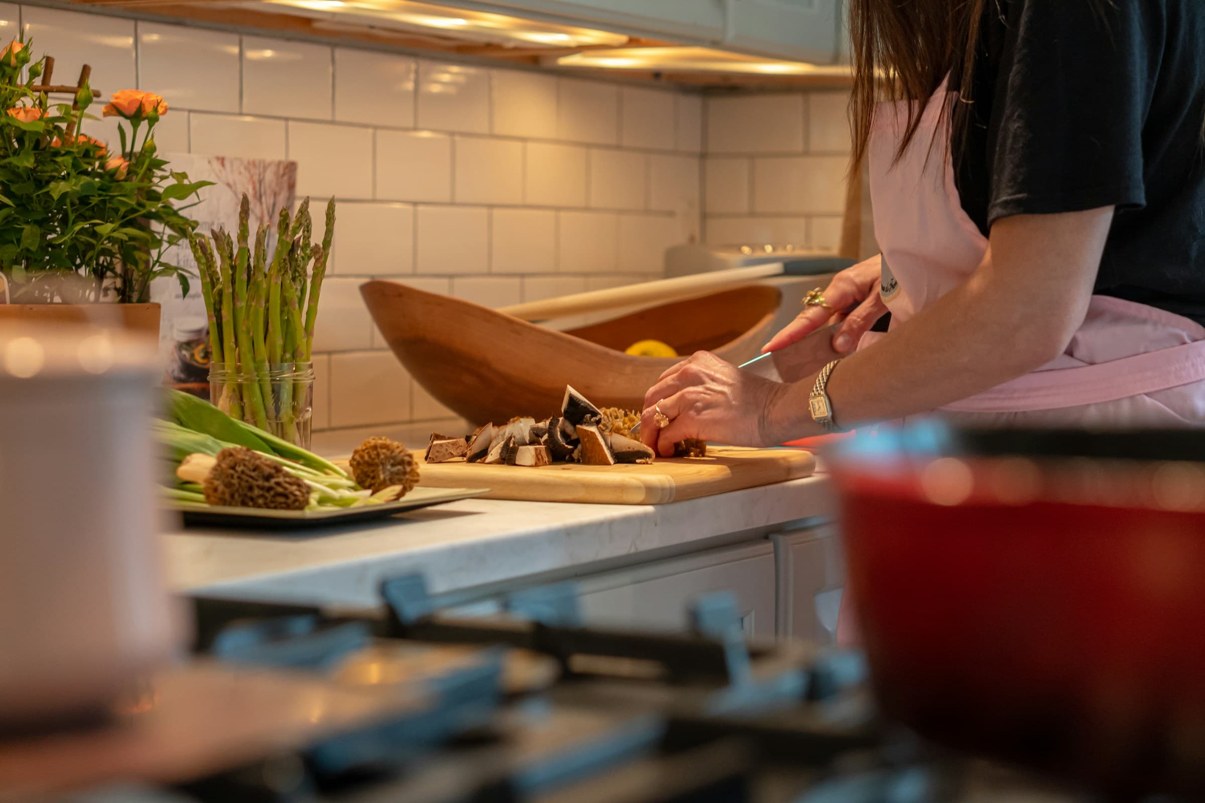 Handen snijden groente op een aanrecht in een keuken.
